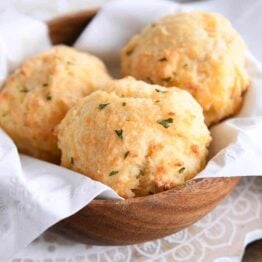 easy cheesy garlic drop biscuits in wooden bowl with white napkin