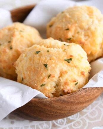 easy cheesy garlic drop biscuits in wooden bowl with white napkin