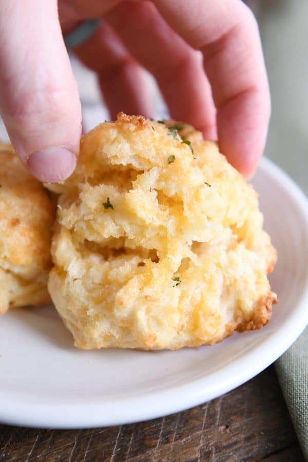 Pulling a cheesy garlic drop biscuit apart in half.