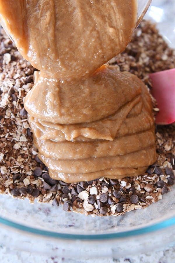 Adding peanut butter syrup to granola mixture.