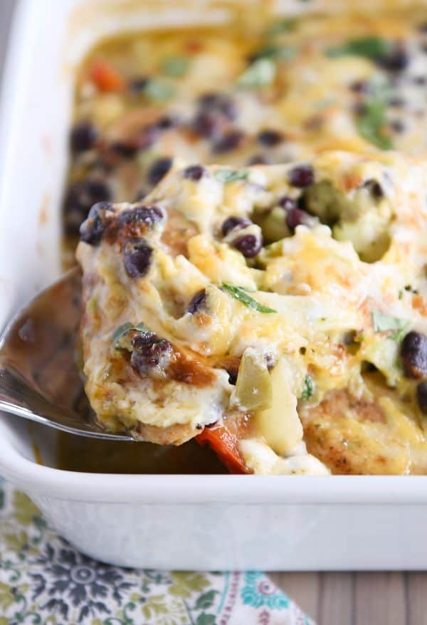 scooping up chicken and vegetables from cheesy chicken enchilada bake