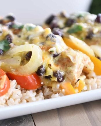 cheesy chicken enchilada bake over brown rice on white platter