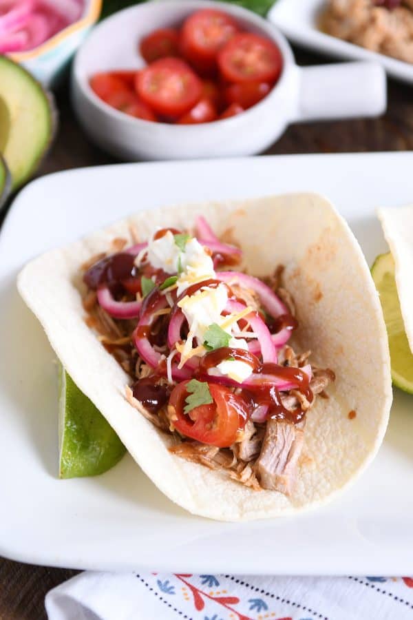 Taco made from instant pot bbq pork taco meat and pickled onions and drizzled with bbq sauce.