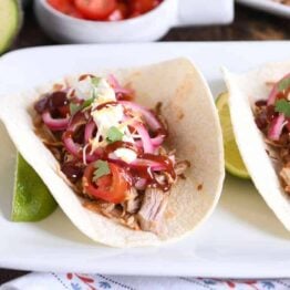 taco made from instant pot bbq pork taco meat and pickled onions and drizzled with bbq sauce