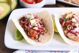 taco made from instant pot bbq pork taco meat and pickled onions and drizzled with bbq sauce