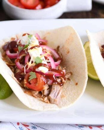 taco made from instant pot bbq pork taco meat and pickled onions and drizzled with bbq sauce