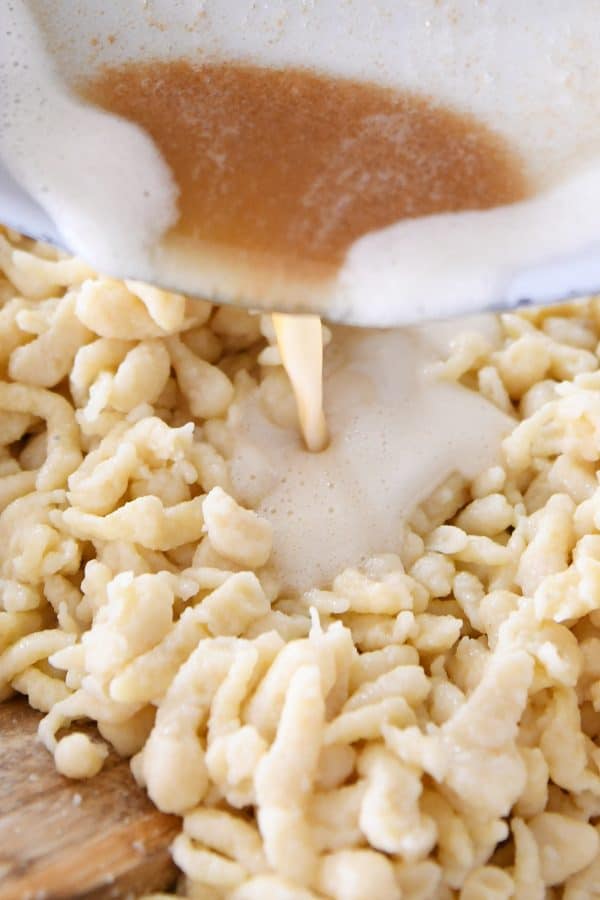 Pouring browned butter over homemade German spaetzle.