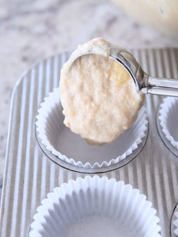 Dropping banana muffin batter into muffin tins with cookie scoop.