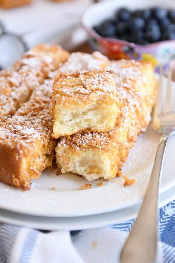 crunchy baked french toast sticks with powdered sugar on white plate