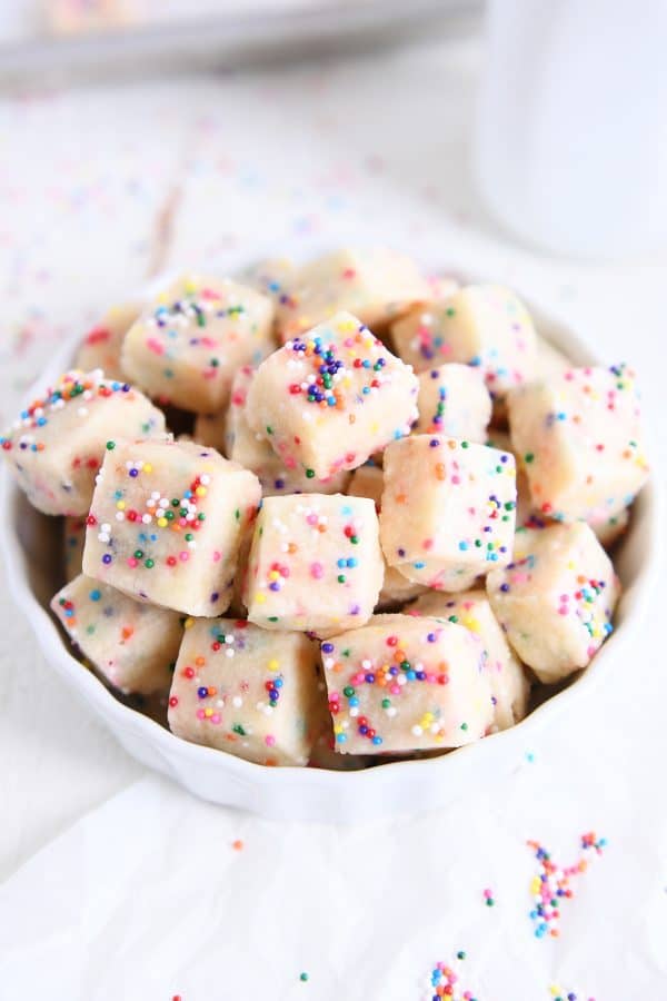 Top down view of baked funfetti shortbread bites in white bowl.