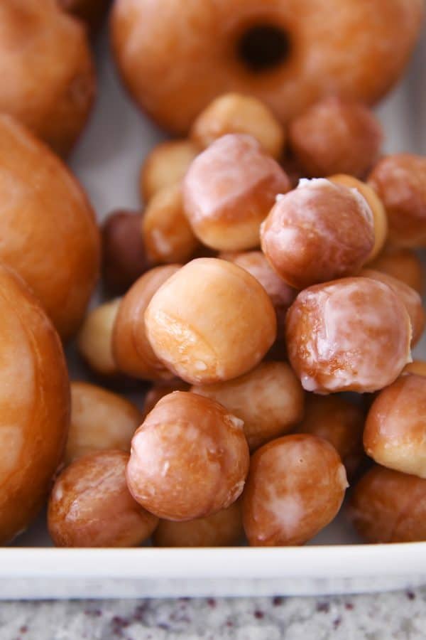 Glazed donut holes in white pan.