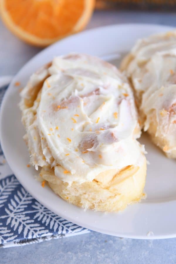 Homemade orange sweet roll on white plate.