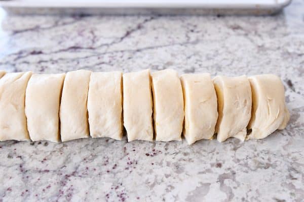 Log of orange sweet rolls sliced into circles.