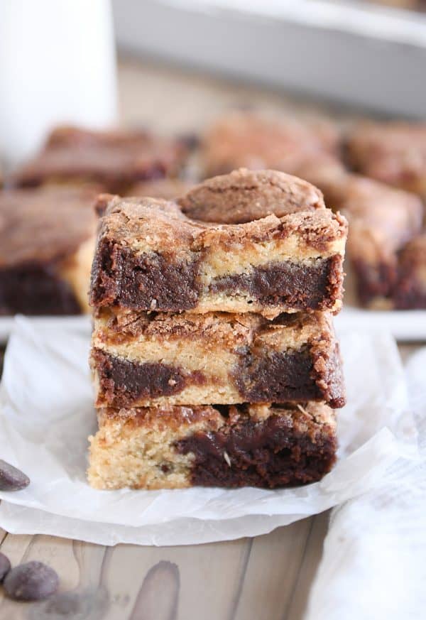 three snickerdoodle brookie bars stacked on white parchment paper