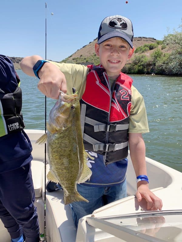 kids catching fish on boat