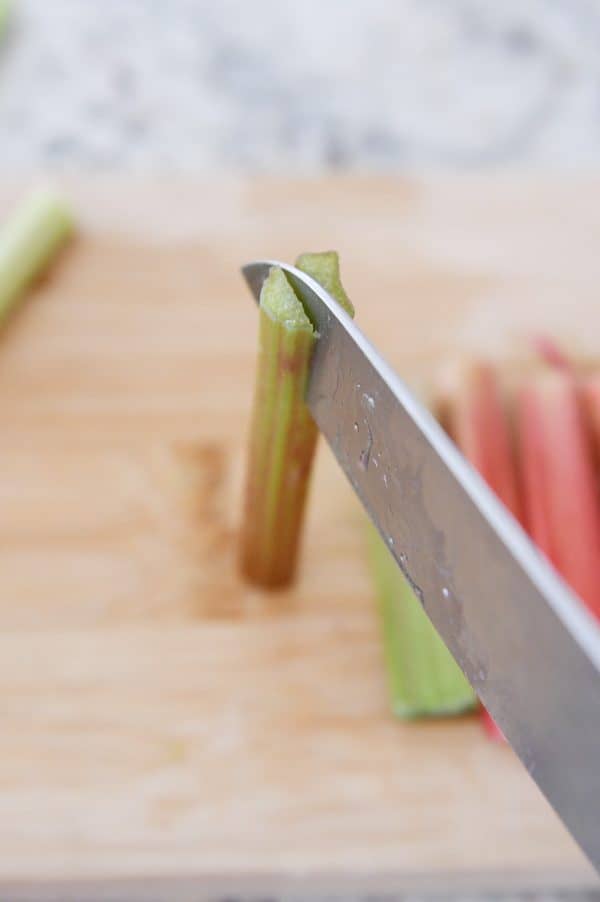 Slicing rhubarb stalk in half lengthwise.