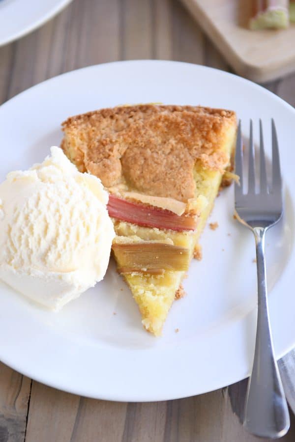 top down view of triangle piece of rhubarb custard cake on white plate