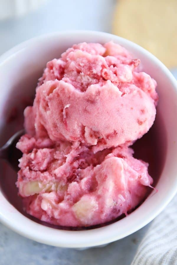 Top down view of frozen pink sorbet in white dish.
