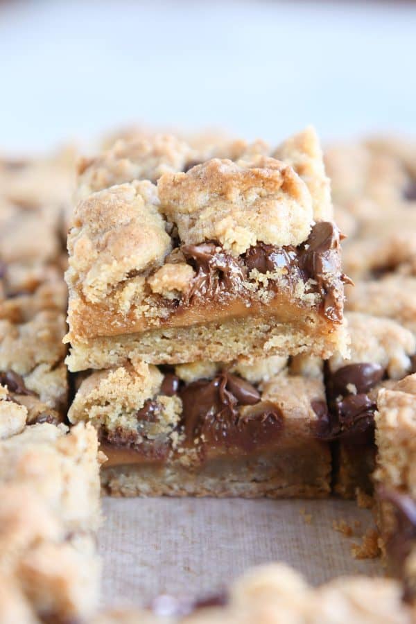 cookie bar cut into square and sitting on top of pan of cut bars