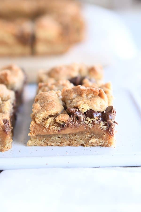 Soft and chewy caramel cookie bar on white platter.