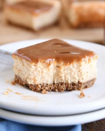 dulce de leche cheesecake square on white plate with bite taken out