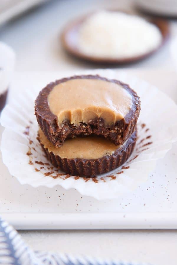 two unwrapped no-bake peanut butter cups stacked with bite taken out of top pb cup