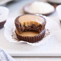 two unwrapped no-bake peanut butter cups stacked with bite taken out of top pb cup