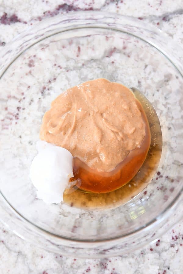 Bowl with coconut oil, maple syrup and natural peanut butter.