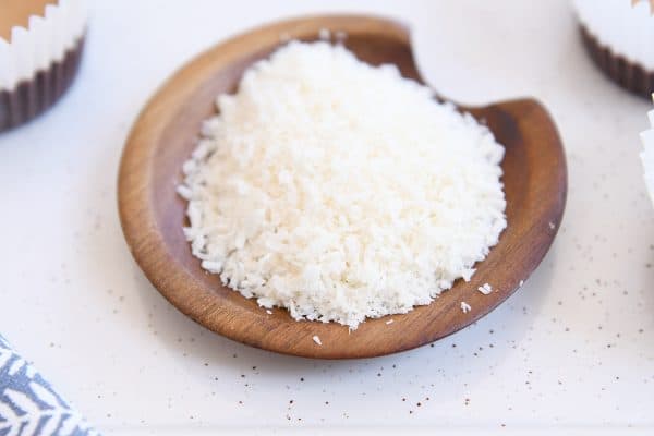 Shredded coconut in shallow wood bowl.