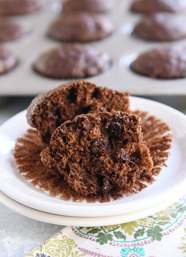 Double chocolate zucchini muffin in half on muffin liner.