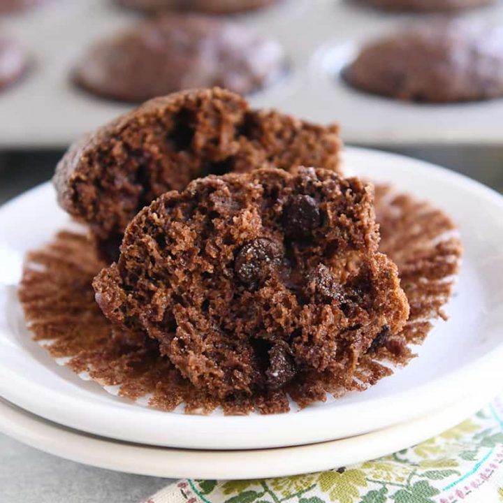 double chocolate zucchini muffin in half on muffin liner