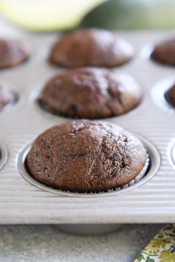 Baked zucchini muffin in aluminum muffin tin pan.