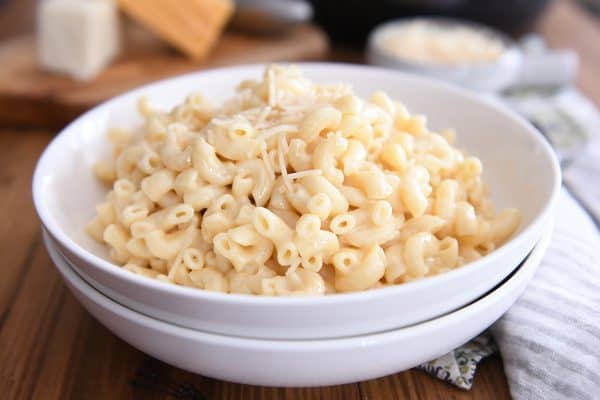 mac and cheese in white bowl with Parmesan sprinkled on top