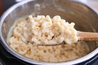 scooping up warm pressure cooker mac and cheese on wooden spoon