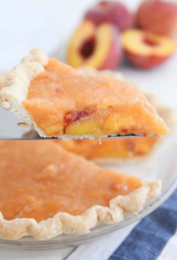 Slice of fresh peach pie on pie server.