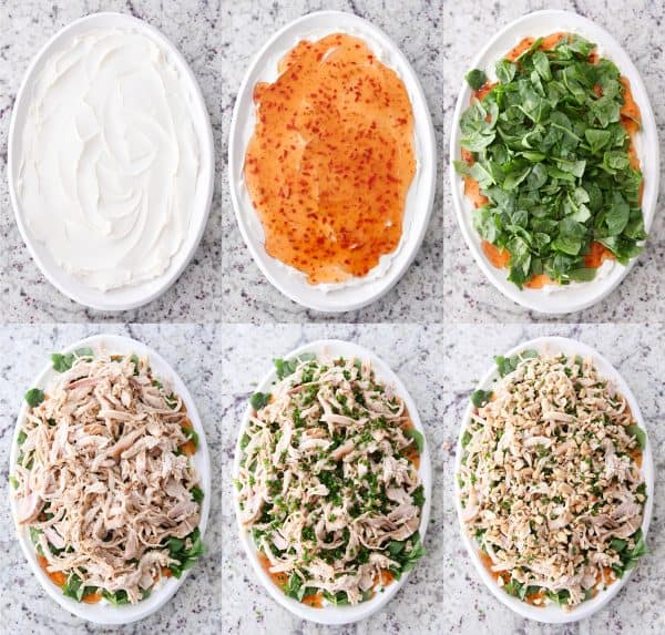 white platter with cream cheese, white platter with sweet thai chili sauce on cream cheese, white platter with spinach on top of chili sauce, white platter with shredded chicken on top of spinach, white platter with chives added, white platter with chopped peanuts