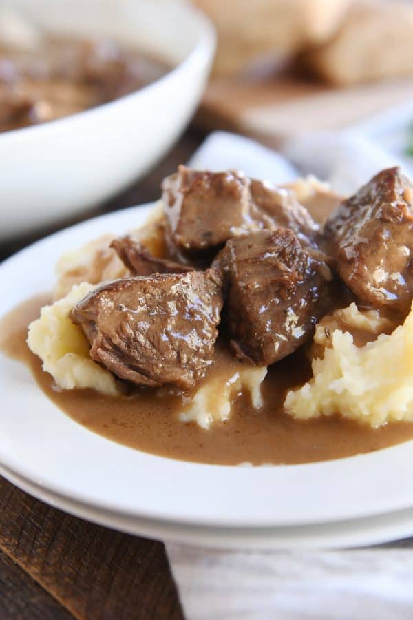 slow cooker smothered beef tips and gravy on mashed potatoes