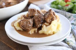 smothered beef tips and mashed potatoes on white plate