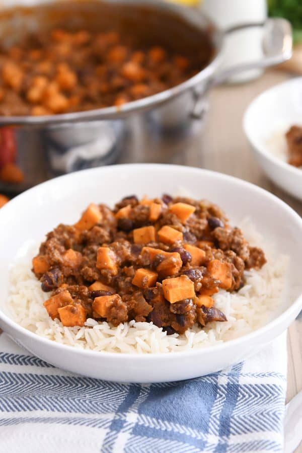 White bowl with rice and sweet potato black bean burrito filling.