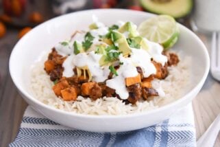 white rice topped with sweet potato black bean burrito ingredients, avocados, cilantro and limes