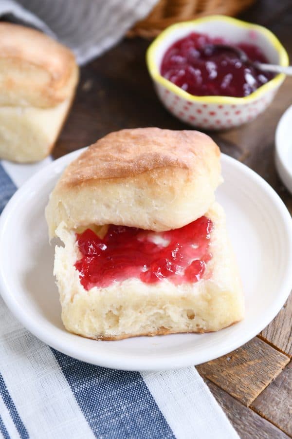 Fluffy dinner roll cut in half and spread with butter and jam.