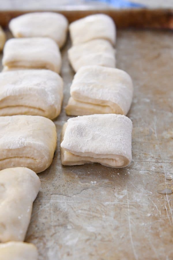 folded unbaked rolls on buttered sheet pan