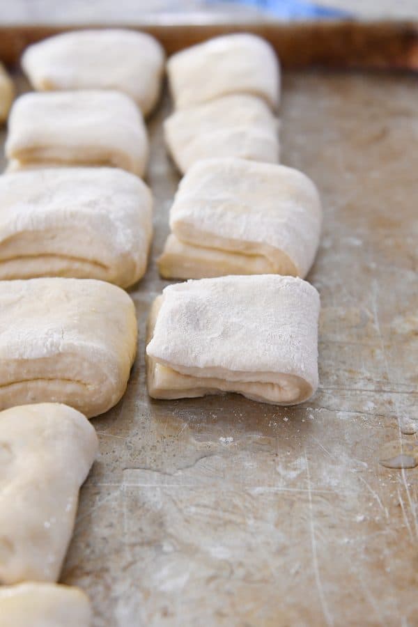 Folded unbaked rolls on buttered sheet pan.