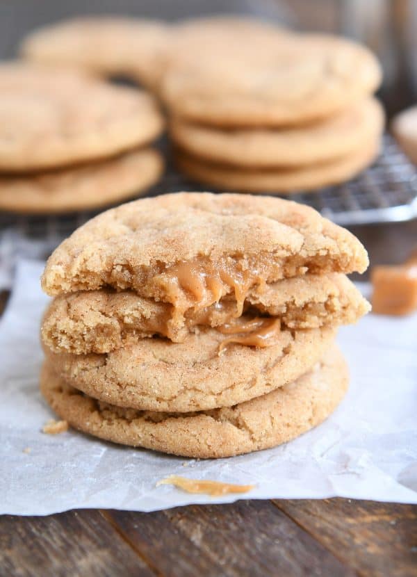 Two brown butter caramel snickerdoodles stacked with one cookie broken in half on top.
