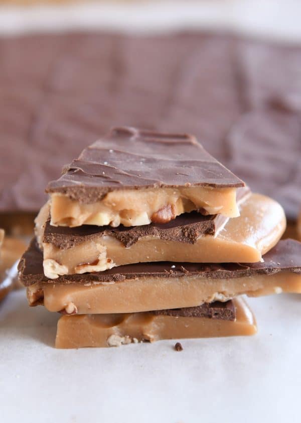 four pieces of homemade toffee stacked on white parchment paper