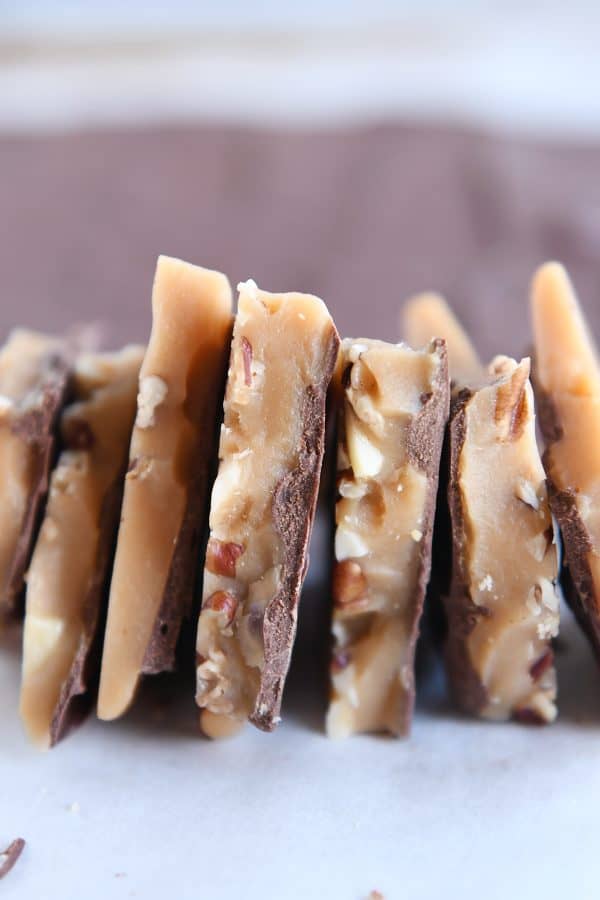 seven pieces of homemade toffee side by side on parchment paper