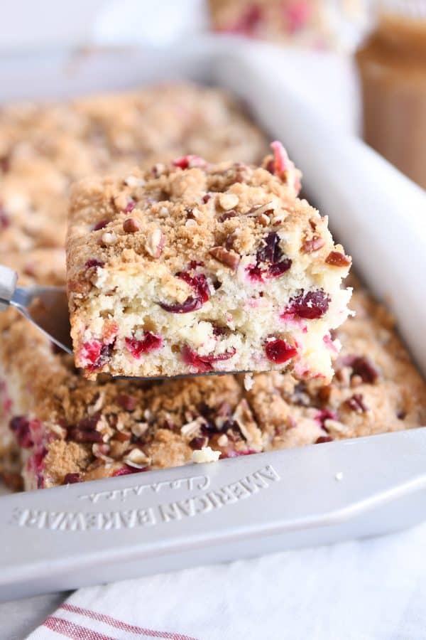 square of cranberry coffee cake on spatula over 9x13-inch pan