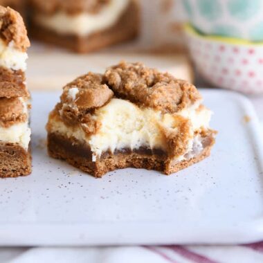 gingerbread cookie cheesecake bar with bite taken out on white tray