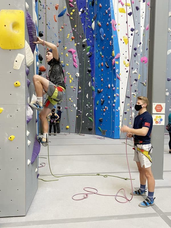 two teenage boys rock climbing