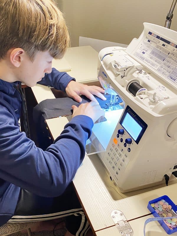 boy sewing black fabric